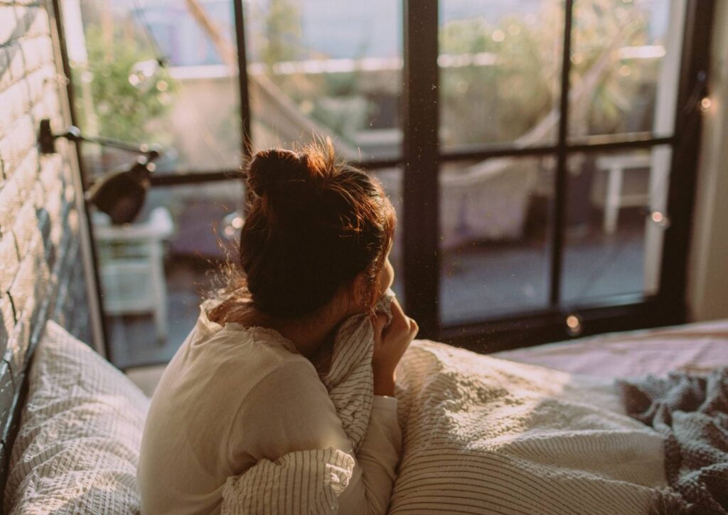 Stille Morgenszene mit Frau die noch müde ist im Bett, ruhiges Licht